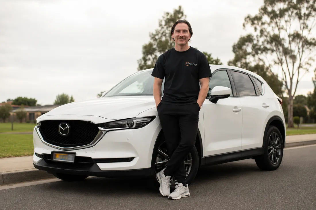 Callum Sullivan with the Function Over Form mobile physiotherapy car on the Northern Gold Coast